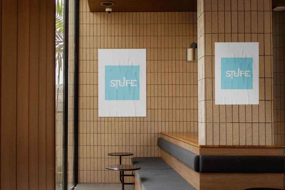 Pale blue STUFE posters displayed in a tiled interior.