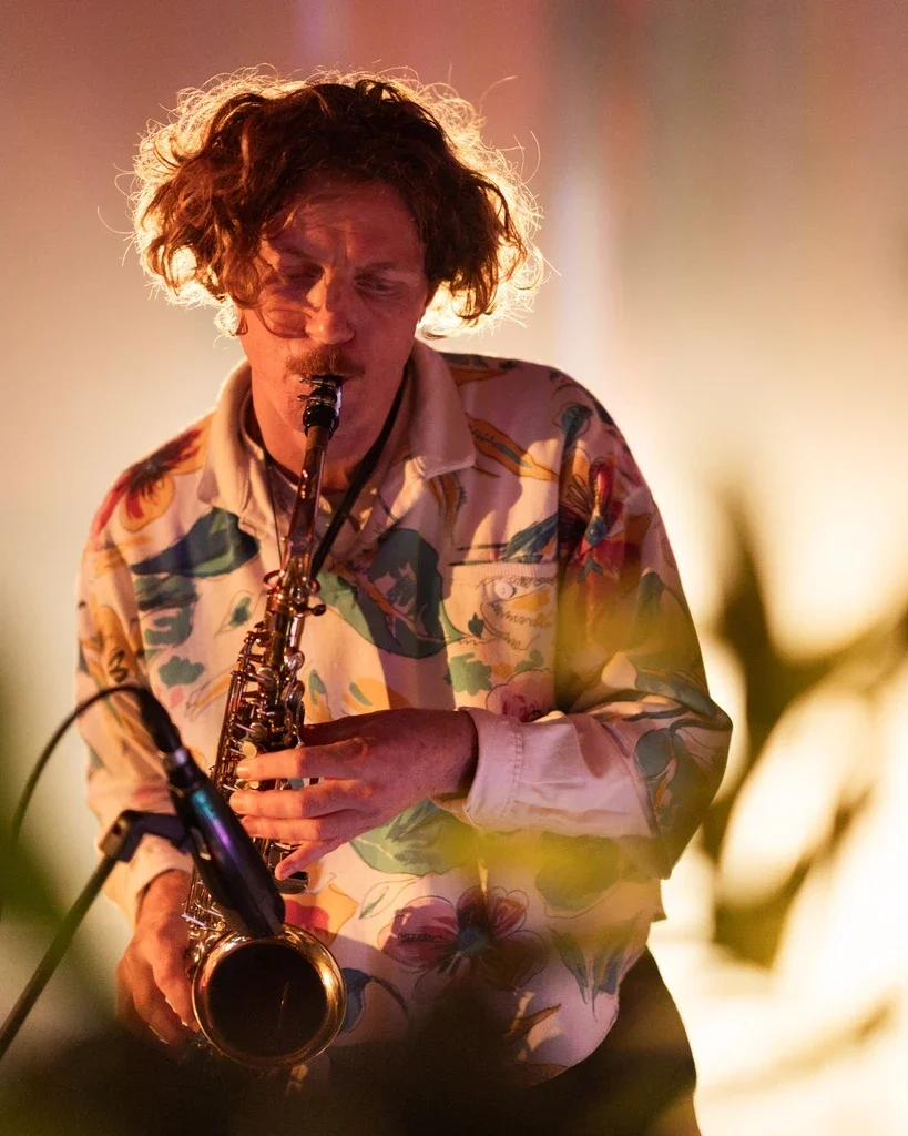 A saxophonist in warm stage light during Encounters.