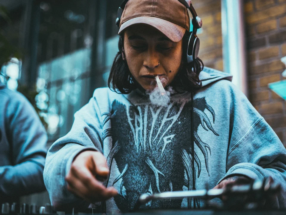 A musician works at a controller outdoors.